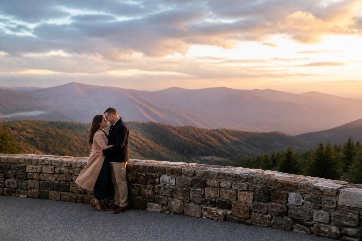 Engaged couple standing together at a safe mountain overlook in a wide scenic portrait
