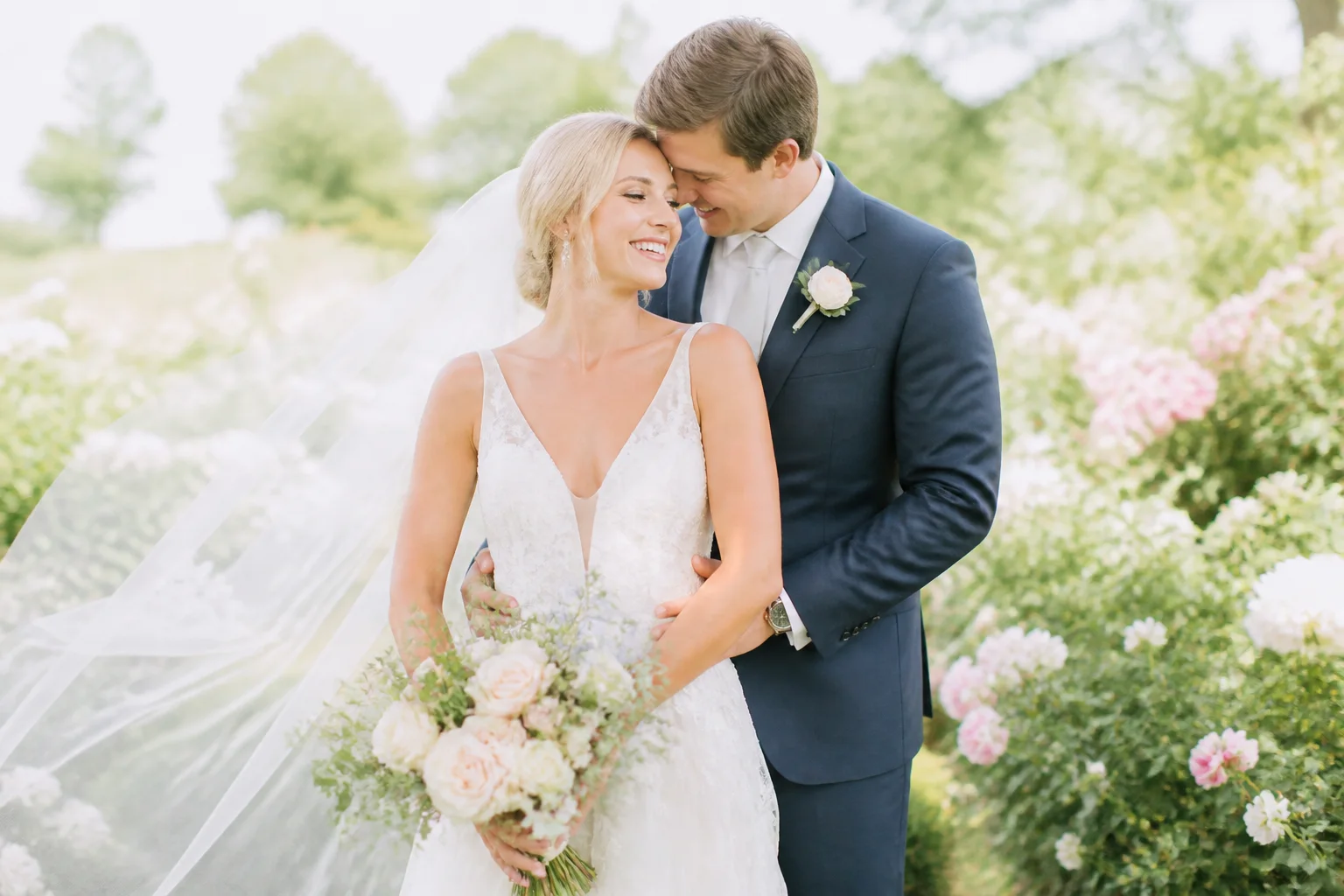Bright light-and-airy wedding portrait in a pale garden setting