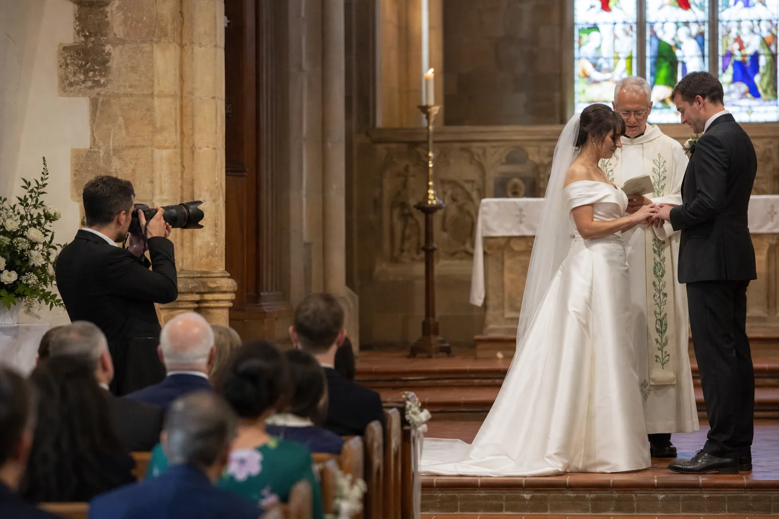Wedding photographer quietly covering a ceremony from beside the aisle