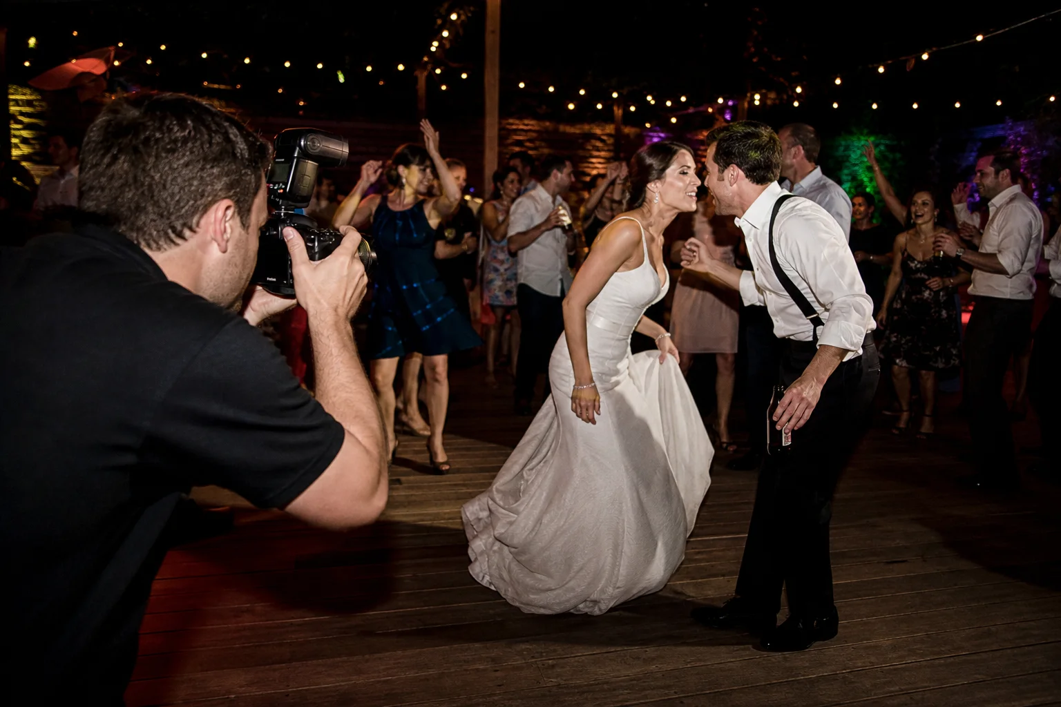 Wedding photographer using flash to photograph an energetic reception dance floor